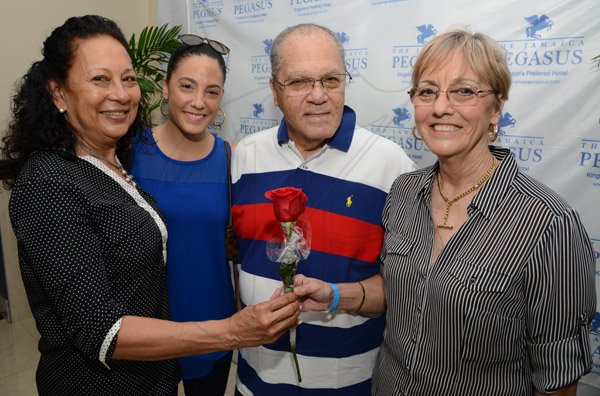 Rudolph Brown/Photographer
Chef. Loraine Fung, (left) give a rosese to Patricia Foote her husband Dr. the Hon. Arnold Foote and daughter Kimberly Foote, (second left) looks on at the Jamaica Pegasus Hotel Mothers Day celebration bunch at Pegasus on Sunday, May 8, 2016