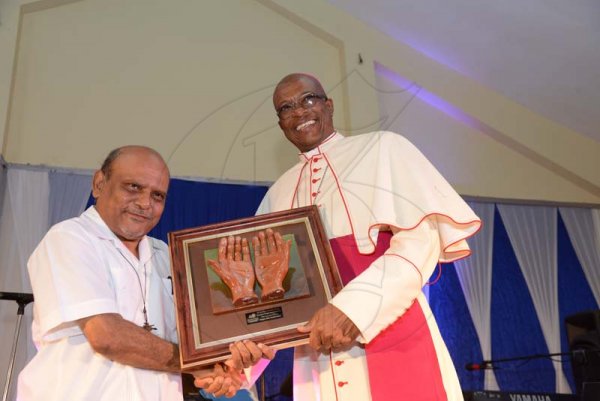 Rudolph Brown/PhotographerArchbishop of Kingston, Rev. Kenneth Richards, (right) presents award for 40 year of service to Rev. Msgr. Gregory Ramissoon, Founder of Mustard Seed at the Mustard Seed communities 40th anniversary awards and banquet at the St. Peter and Paul Church Hall on Saturday, September 8, 2018