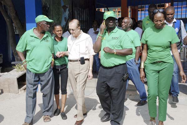 Collin Hamilton / Freelance Photographer

Former Prime Minister Edward Seaga (Second left) is being guided by JLP party supporters as he makes his way to the Tivoli Gardens High School in West Kingston to cast his ballot.