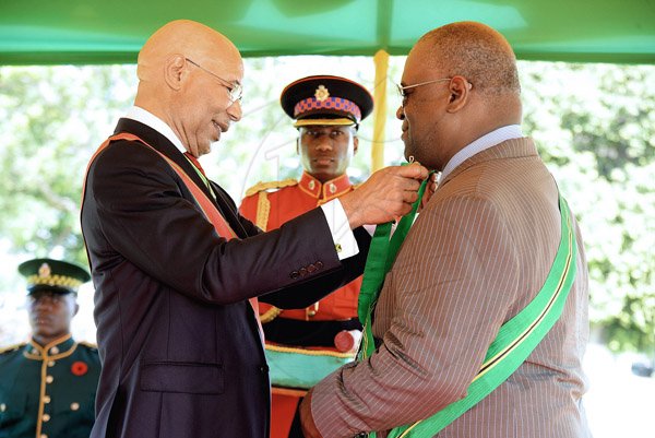 Lionel Rookwood/PhotographerVincent Stephen Francis,OD recieves The Order Of Jamaica from Governor General Sir Patrick Allen at The National Awards held at King's House on Monday October 16,2017. *** Local Caption *** Lionel Rookwood/PhotographerWell done! World renowned track coach Vincent Stephen Francis (right), OD, recieves The Order Of Jamaica from Governor General Sir Patrick Allen at The National Awards held at Kings House yesterday.