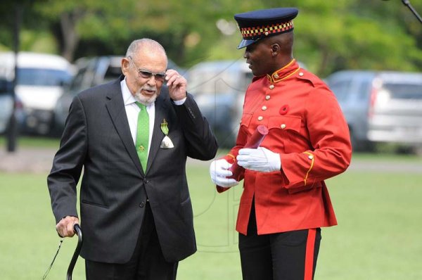 Lionel Rookwood/PhotographerHerbert Ziadie is escorted by a JDF soldier after being awarded the Order of Distinction in the rank of officer at the Presentation of National Honours and Awards held at King's House on October 15th,2018.
