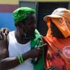Despite supporting two different parties, Aggi (left) and his good friend, Abba, enjoyed a few bottles of beers during the PNP campaign at Chapelton Family Court, Main Street Chapelton on August 18, 2020.