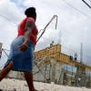 Ricardo Makyn/Staff Photographer 
A lady walks by a building under construction on Burke Road in Spanish Town.