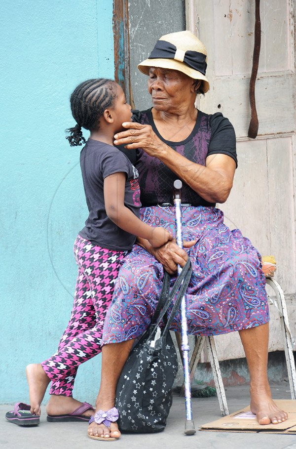 Jermaine Barnaby/Photographer
This senior citizen was seen with a little girl along Main Street in St Ann's Bay during a tour of parish capital, St Ann's Bay on Saturday March 21, 2014.