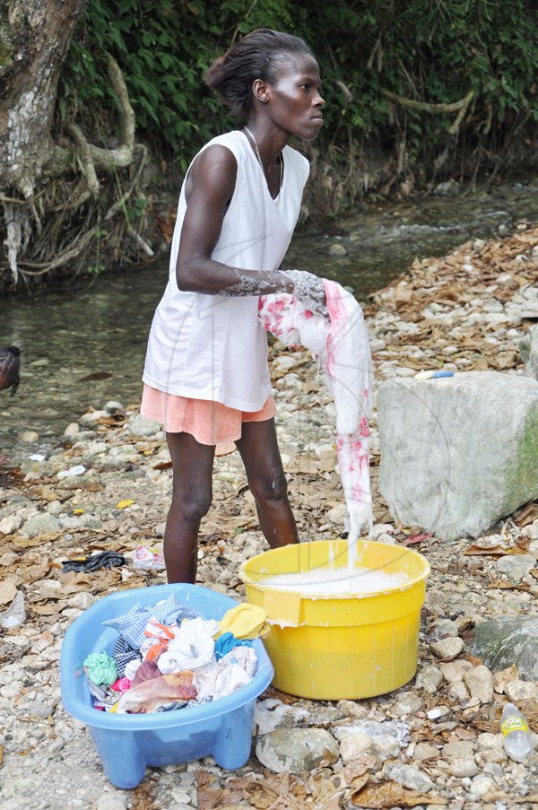 Jermaine Barnaby/Photographer
Kareen Clarke carries out her domestic chores at Whiteriver during a tour of parish capital, St Ann's Bay on Saturday March 21, 2014.