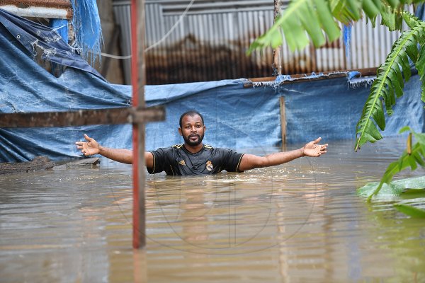 Dwayne McKoy, a resident of Grants Crescent in Hampton Green, Spanish Town, wades through chest-high floodwaters to the rear of his home, from which he operates a furniture workshop. McKoy said that flooding has been a long-standing issue in the Spanish Town community