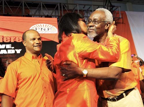 Ricardo Makyn/Staff Photographer
Former prime minister PJ Patterson receives  a kiss from People's National Party (PNP) President Portia Simpson Miller while General Secretary Peter Bunting looks on during the  PNP's 73rd Annual Conference at the National Arena yesterday.