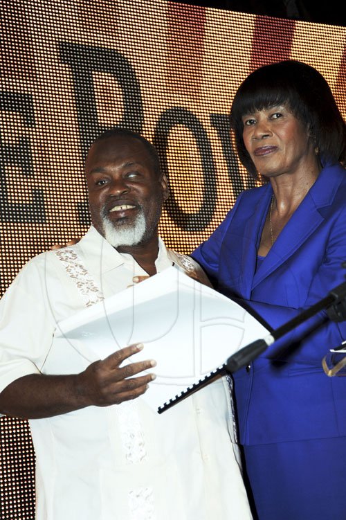 Norman Grindley/Chief Photographer
People's National Party President (PNP) Portia Simpson Miller  presents a copy of the manifesto in braille to Derrick Palmer during the launch of the PNP manifesto at the Wyndham hotel in New Kingston yesterday.