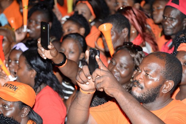 Jermaine Barnaby/Photographer
PNP supporters at the recording some of the action onstage at the rally in St Thomas on Sunday November 29, 2015.