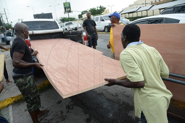 Rudolph Brown/PhotographerWorkmen carry ply board from the Super Valu Home Centre in Liguanea in preparation for Hurricane Matthew on Saturday, October 1, 2016