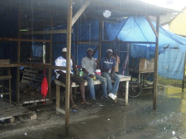 These young men, from left, Pabo, Natty Ray and Lennie Hyde, all of Boundbrook, Portland, were spotted along West Street in Port Antonio, sitting on a stall sharing a flask of rum yesterday during the rain. They claimed they are awaiting the arrival of Tropical Storm Tomas.
