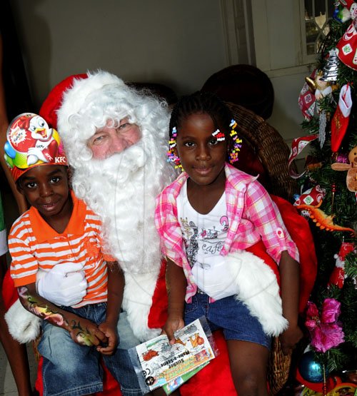 Winston Sill / Freelance Photographer
Prime Minister Andrew Holness and wife Juliet host Children Christmas Treat, held at Vale Royal, St. Andrew on Wednesday December 14, 2011.  Here are Sabjie Reynolds (left); and Antoinette DuCasse (right) with Santa.