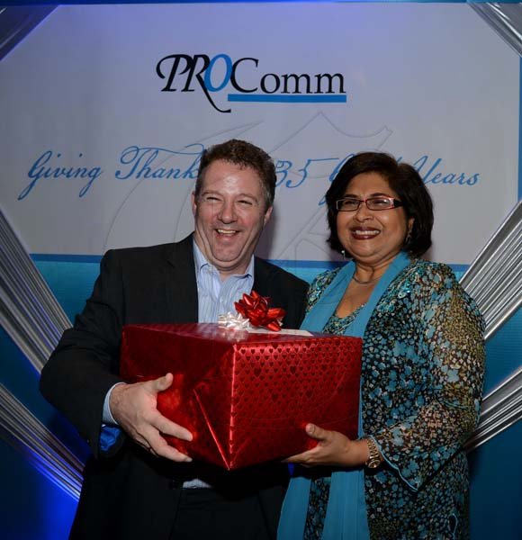 Winston Sill/Freelance Photographer
PRO Com 35th Anniversary Clients and Media Reception, held at the Jamaica Pegasus Hotel, New Kingston on Wednesday night December 4, 2013. Here Andy Thorburn (left), of Digicel presenting Jean Lowrie-Chin with a  birthday gift.