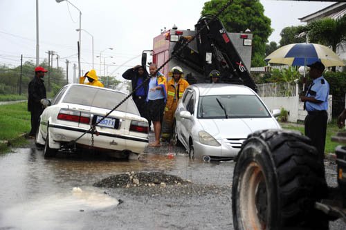 Norman Grindley/Chief Photographer
Two cars got stuck in a broken main on Palmoral Avenue in Mona Heights during flood rains in St. Andrew yesterday.