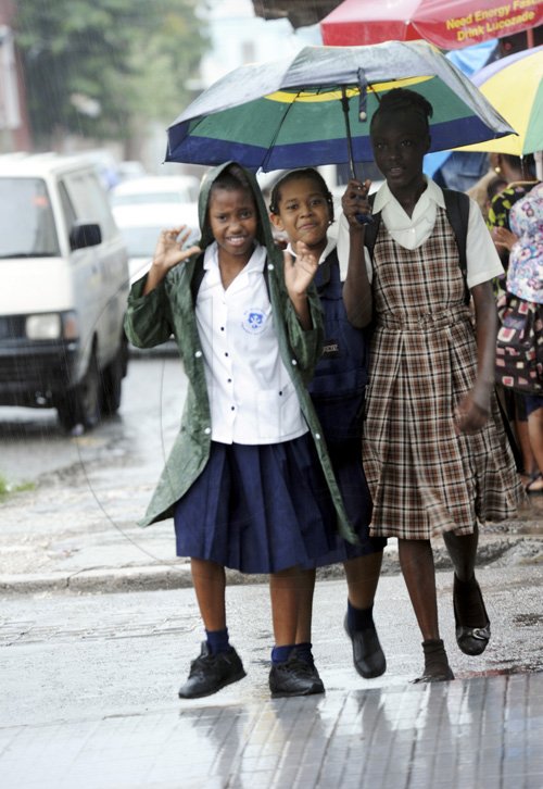 Norman Grindley /Chief Photographer
Children shelter from the rain on their way home from school in downtown Kingston on Wednesday