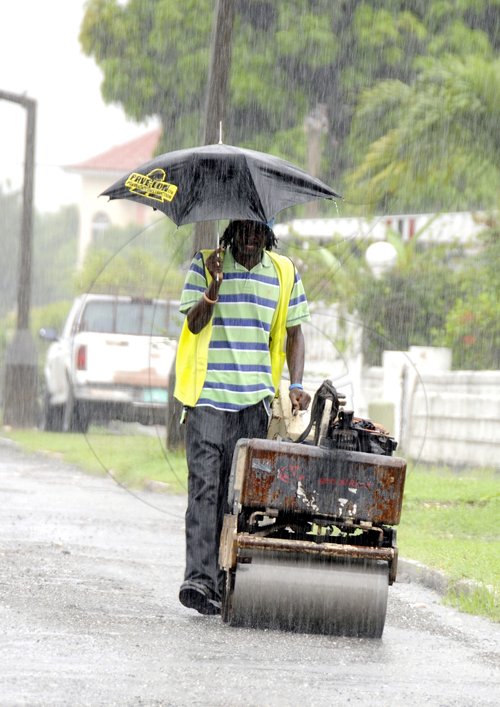 Gladstone Taylor / Photographer

A construction worker on Palmoral Avenue, Mona Road, St. Andrew, was observe yesterday working in the heavy down pour, as flood rains affected section of the island yesterday.