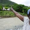 Ricardo Makyn/Staff Photographer
Memry Edie 56 Years Old points to Her Home across the Yallahs River in the Gordon Castle Distrcit Llandewey St Thomas,where a section of the Wooden Bridge as washed away and residents have to walk through the River in order to get Home.