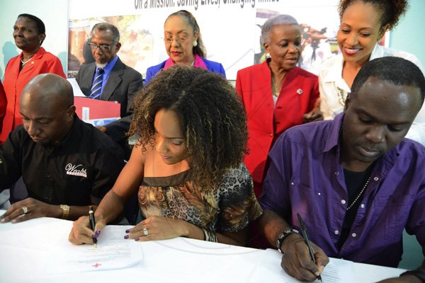 Rudolph Brown/Photographer
Bridgette Foster Hylton, (centre)  Garth Walker, (left) and Ity, (right) signing the Red Cross members form while looking on from left are Lois Hue, Dr. Jaslin Salmon, Vice President, International Federation of Red Cross, Dr. Marion Bullock-DuCasse, director,  Health Ministry's Emergency Disaster Management and Special Services,  Yvonne Clarke, Director General of Red Cross and Allison Watson  at the Jamaica Red Cross 2012 Launch Membership Campaign media briefing at Knutsford Court Hotel on Monday, October 8, 2012