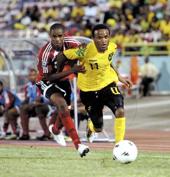 Ricardo Makyn/Staff Photographer.
Jamaica's Dane Richards slips by Trinidad and Tobago's Jovian Jones during yesterday's friendly international at the National Stadium. Richards scored the lone goal, a penalty, to win the football match.