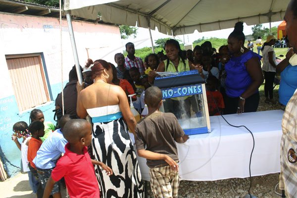 Christopher Serju/Gleaner Writer
Birthday celebration - Children and adults alike watch in fascination as the operator crushes ice to make sno cones.