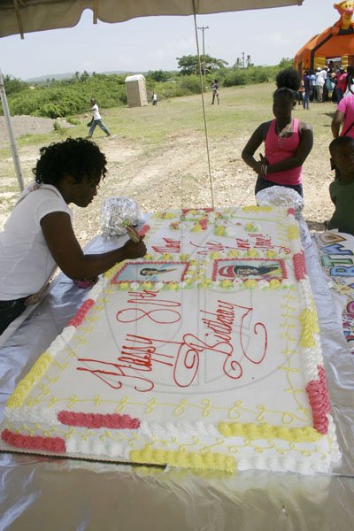 Christopher Serju/Gleaner Writer
A decorator puts the finishing touches on the whopping 48-inch by 54-inch birthday cake which was part of the 80th birthday celebration for Rezna Miller on Saturday.