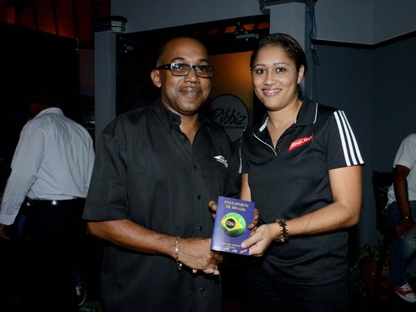 Winston Sill/Freelance Photographer
Ribbiz Ultra Lounge host the Grand Unveiling of World Cup Viewing Party, held at Batbican Centre, East King's House Road on Wednesday night June 11, 2014. Here Erin Mitchell (right), Brand Manager, Red Stripe presents the first Entry Passport to David Magnus (left). The Passport allows free access to all World Cup Football viewing event at Ribbiz.