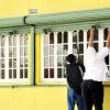 Norman Grindley / Staff Photographer
Business operators pull down their shutters in downtown Kingston early yesterday afternoon.