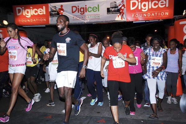 Colin Hamilton/Freelance Photographer
Kingston's Mayor Angella Brown-Burke (centre, white top) begins her journey, along with other competitors, in Saturday's Digicel 5K Night Run/Walk Downtown Kingston.

 - October 20, 2012.