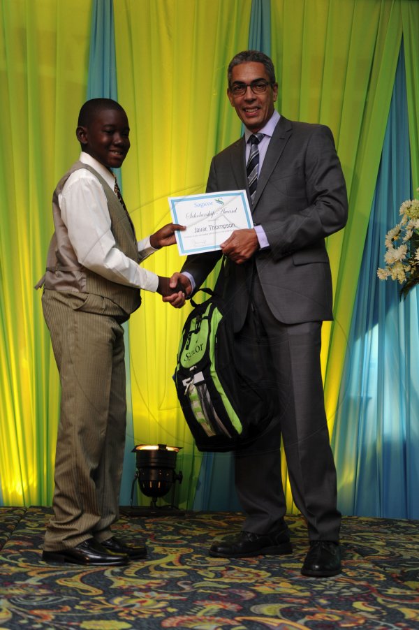 Ricardo Makyn/Staff Photographer
Richard Byles Presdent and Ceo  Sagicor presents Javar Thompson who will be attending Campion College   at the Sagicor annual GSAT awards ceremony at the Knutsford Court Hotel on Thursday 23.8.2012