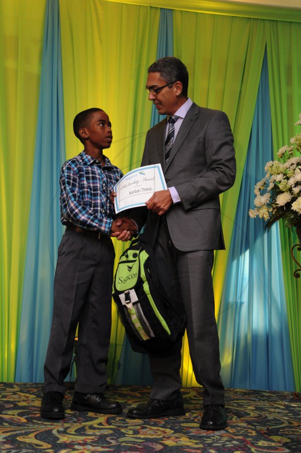 Ricardo Makyn/Staff Photographer
Richard Byles Presdent and Ceo  Sagicor presents Jordan Theoc Who will be attending Campion College   at the Sagicor annual GSAT awards ceremony at the Knutsford Court Hotel on Thursday 23.8.2012