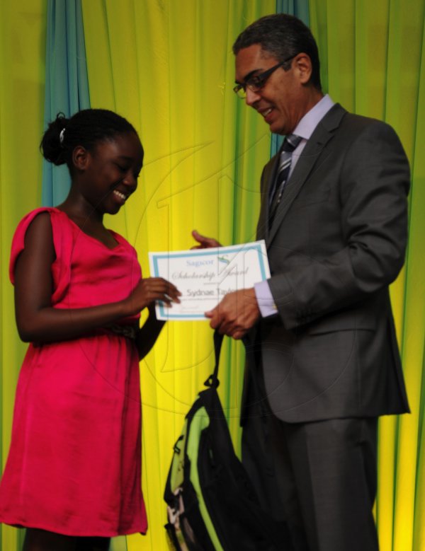 Ricardo Makyn/Staff Photographer
Richard Byles Presdent and Ceo  Sagicor presents Sydae Taylor who will be attending Campion College  at the Sagicor annual GSAT awards ceremony at the Knutsford Court Hotel on Thursday 23.8.2012
