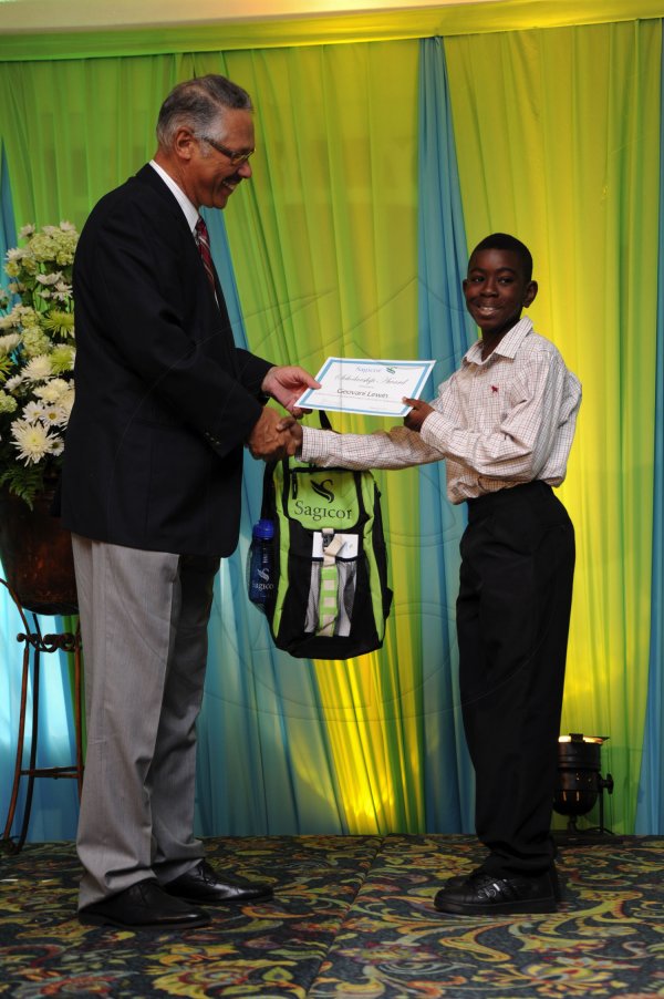 Ricardo Makyn/Staff Photographer
Errol McKenzie Executive Vice President Sagicor presents Geovanni Lewin who will be atteending Wolmers High School   at the Sagicor annual GSAT awards ceremony at the Knutsford Court Hotel on Thursday 23.8.2012