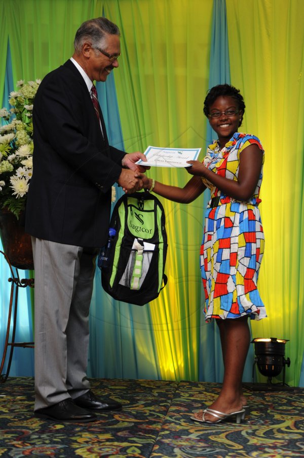 Ricardo Makyn/Staff Photographer
Errol McKenzie Executive Vice President Sagicor presents  Olivia Lawrence who will be attending Wolmers Girl's  at the Sagicor annual GSAT awards ceremony at the Knutsford Court Hotel on Thursday 23.8.2012
