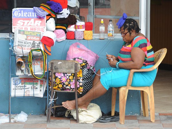Jermaine Barnaby/Photographer
A woman seen knitting crochet outside a store along Main Street in St Ann's Bay during a tour of parish capital, St Ann's Bay on Saturday March 21, 2014.