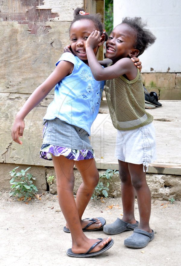Jermaine Barnaby/Photographer
Shantol Thomas (left) was caught having fun with friend Towannie Wilson in the Riverlane community of Windsor in St Ann's bay during a tour of parish capital, St Ann's Bay on Saturday March 21, 2014.