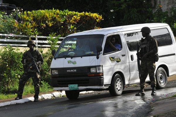 Norman Grindley/ChiefPhotographer
A funeral Home vehicle make it's way down Kirkland close after a Military operation in Sterling Castle in Upper St. Andrew May 27, 2010.