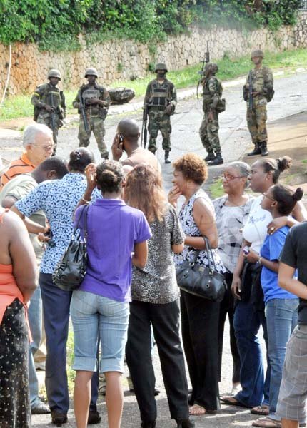 Norman Grindley/ChiefPhotographer
Family and friends of Keith Clarke gather on Kirkland Close where they were barred from the death house by soldiers.


during a military operation in Sterling Castle yesterday.

 in Upper St. Andrew May 27, 2010. Keith Clarke was killed in his home during the operation.
