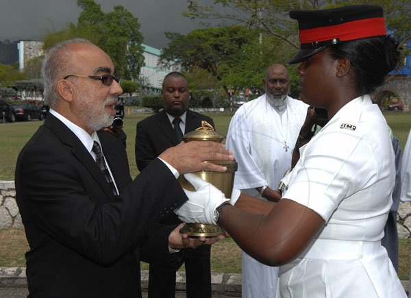 Ian Allen/Photographer
Justice Andrew Rattray left, son of Carl Rattray receive the Urn with the remains of his father from a Woman Constable of Police just after the Official Thankgiving Service at the University Chapel, University of the West Indies Mona.