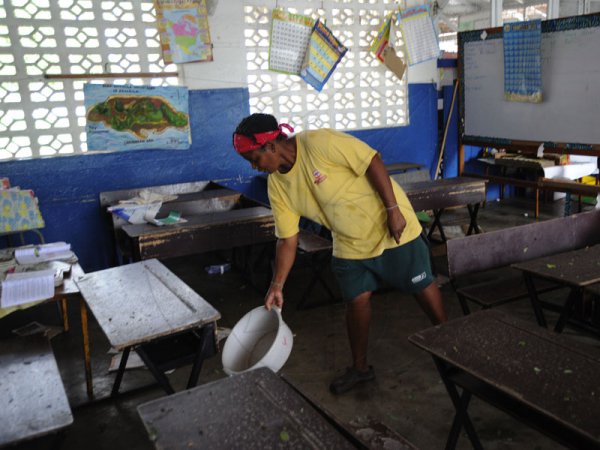 Norman Grindley/Chief Photographer
An employee at the Swallowfield primary and Junior high school in St. Andrew tries to get this class room ready after it was flooded.