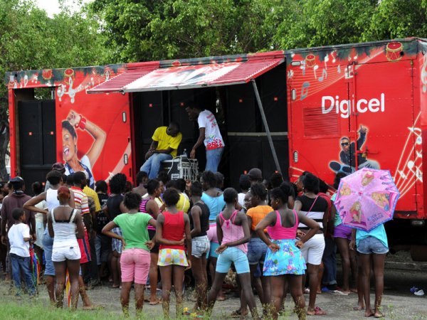 Norman Grindley/Chief Photographer
Digicel customers get free phone charging by their mobile unit on Spanish Town road in Kingston yesterday.