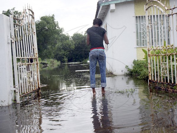 Anthony Minott/Freelance Photographer
A girl walks into a flooded yard in Old Braeton after the passage of Hurricane Sandy in Portmore, St Catherine last Thursday.