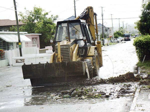 Anthony Minott/Freelance Photographer
 A tractor moves debris that was spilled from a drain in 3 West, Greater Portmore after the passage of Hurricane Sandy in Portmore, St Catherine last Thursday.