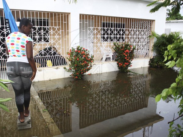 Anthony Minott/Freelance Photographer
Mickayla Laing looks at a neighbour's flooded yard in Old Braeton after the passage of Hurricane Sandy in Portmore, St Catherine last Thursday.