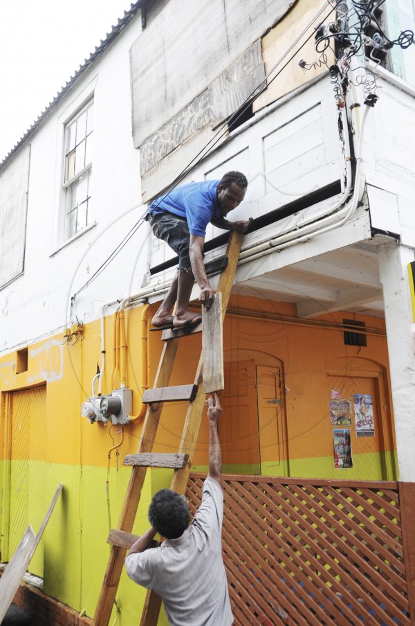 Ricardo Makyn/Staff Photographer
These  resident's  of Port Royal does some repairs to His home in Port Royal before Tropical Storm Sandy hits the island.
