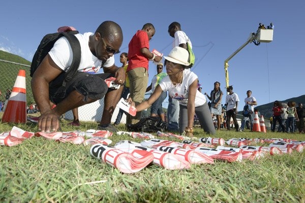 Gladstone Taylor / Photographer

Kenneisha Campbell (right) and Sameer Simms of UWI marketing department are seen counting bibsat the university of the west indies student's and staff  attempt to break the guinnes world record for the longest chain of persons clasping hands in a stance against violence at the uwi mona bowl yesterday evening