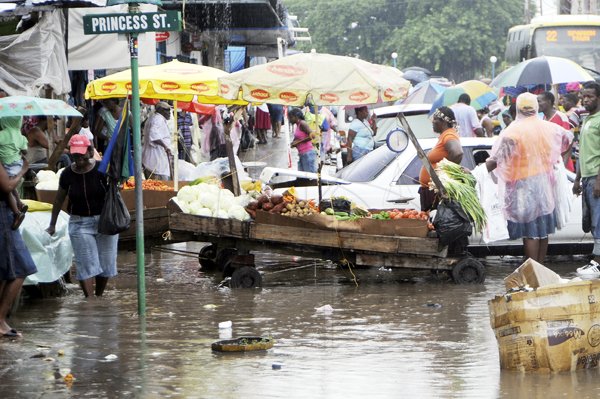 Gladstone Taylor / Photographer

Vendors and shoppers make their way along a flooded Princes Street in cowntown Kingston on Saturday.