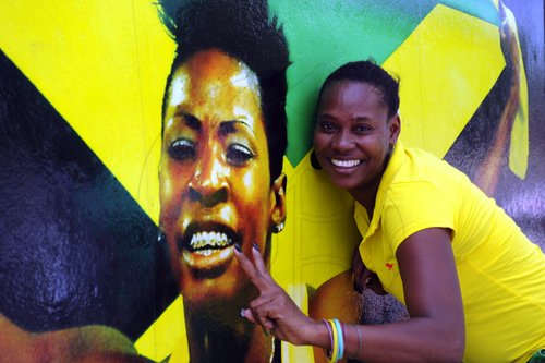 Norman Grindley/Chief Photographer
After Melaine Walker, takes home the Silver in the woman's 400 Hurdles in Daegu yesterday her Jenefer Bercher posed by the mural on Maxfield avenue yesterday morning.