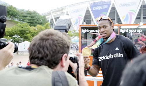 Ricardo Makyn/Staff Photographer 
Yohan Blake shows off his gold medal on Tuesday. Blake won the 100 metre finals, after team mate Usain Bolt false-started.