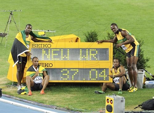 Ricardo Makyn/Staff Photographer
Jamaica's world record setting men's sprint relay quartet pose at the display board showing the new mark, 37.04 seconds, on the final day of the IAAF World Championships in Daegu, South Korea  yesterday. The members of the team (from left) are Nesta Carter, Michael Frater, Yohan Blake and Usain Bolt. The team smashed the 37.10 set by Jamaica at the Beijing Olympics in 2008.2008.