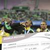 Ricardo Makyn/Staff Photographer
Jamaica's men's 4x100 quartet (from left) Usain Bolt, Yohan Blake, Michael Frater and Nesta Carter display their bonus cheque for establishing a new world record, in the 4x100 metres final at the Daegu Stadium, during the World Athletics Championships in Daegu, South Korea, yesterday. The Jamaicans clocked 37.04 seconds to erase their own mark of 37.10.


 September4, 2011